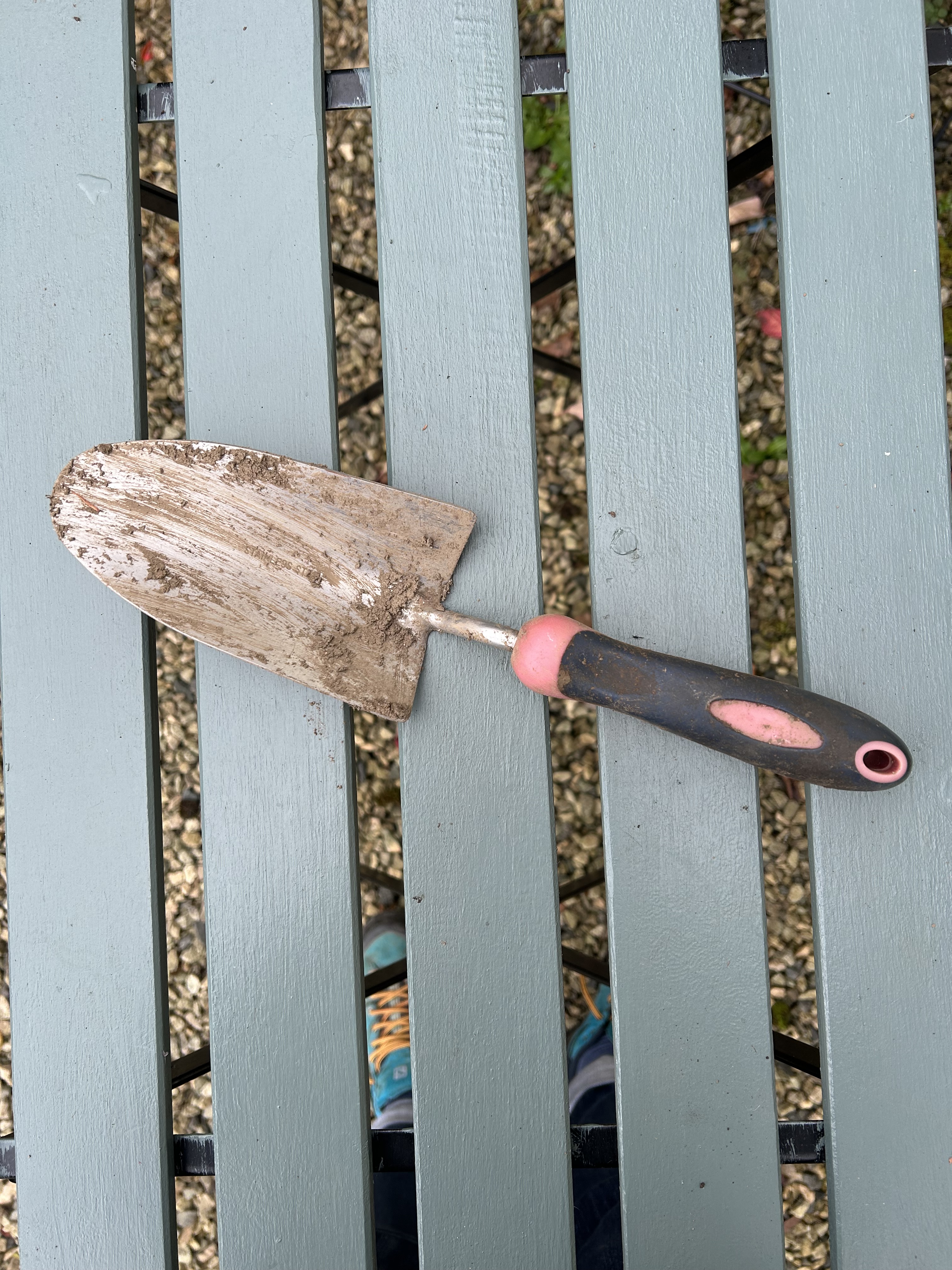 A trowel streaked with mud.