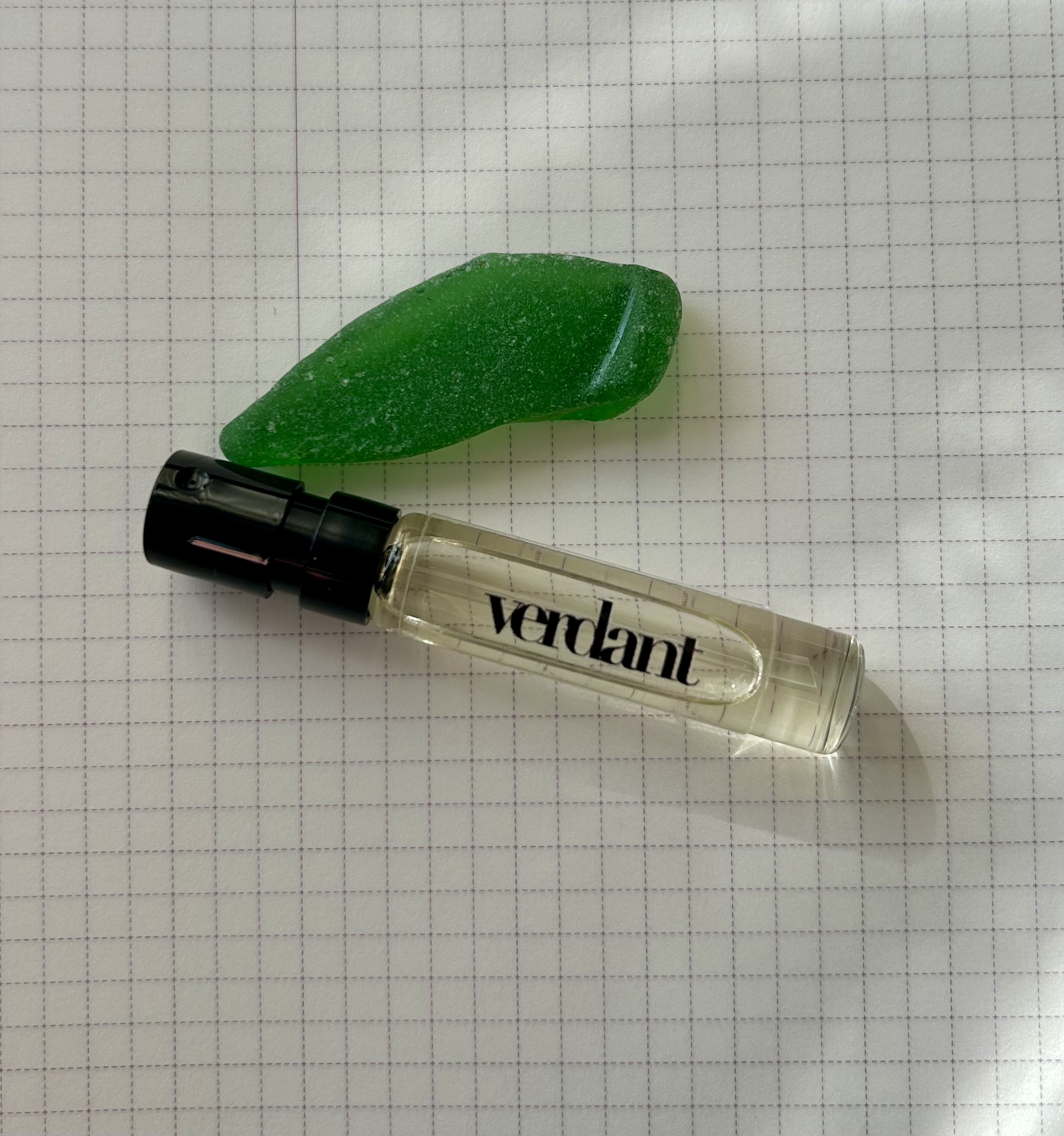 Verdant sample vial with piece of vibrant green sea glass.